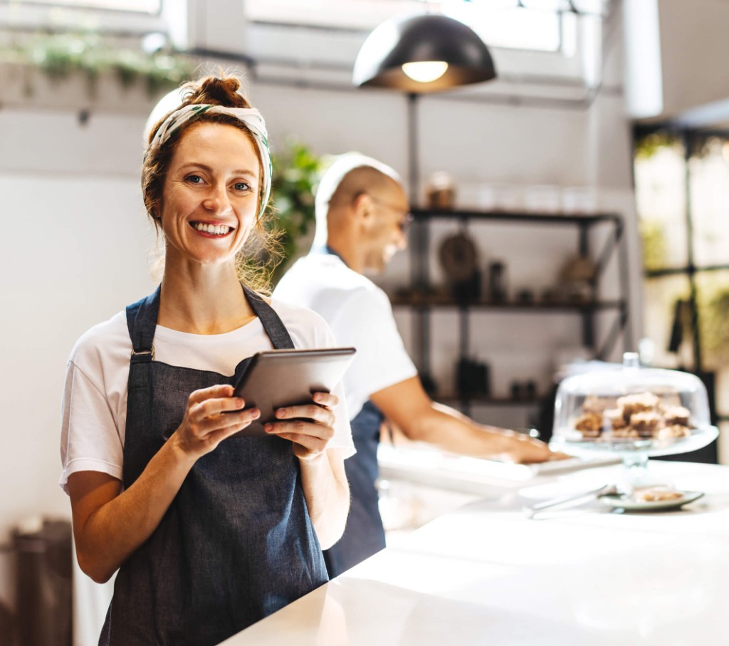 Entrepreneure dans son café tenant une tablette