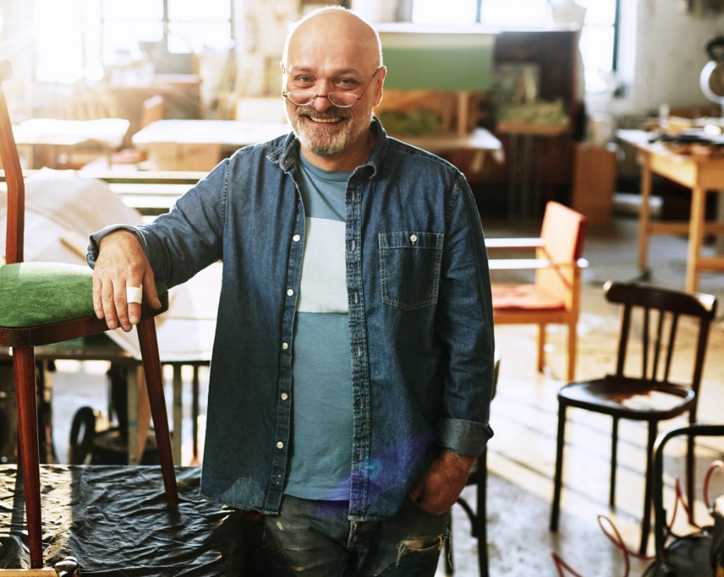Entrepreneur dans son atelier près d'une chaise en bois